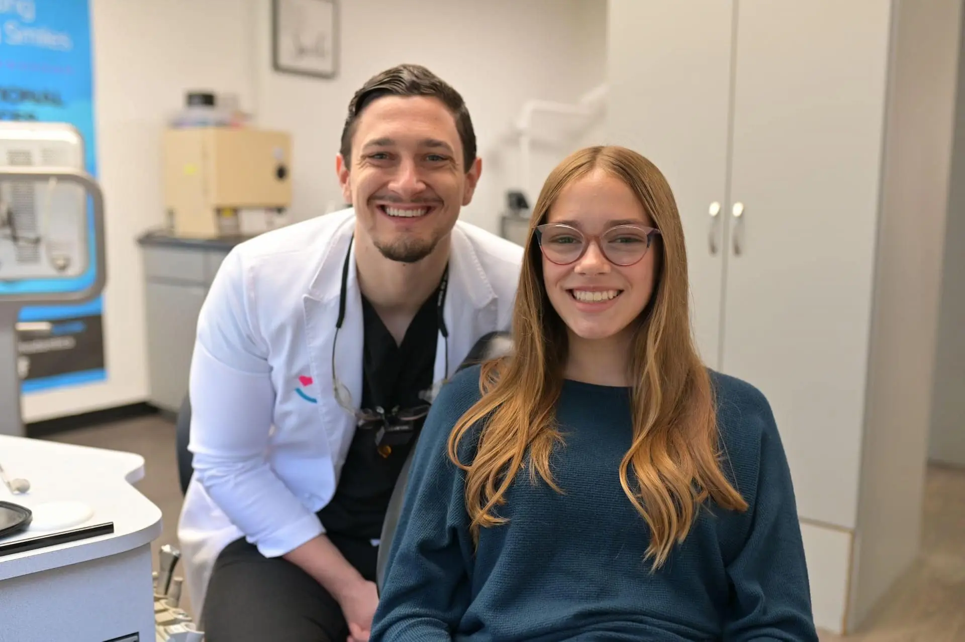 Dr. Cameron Freelove and a smiling patient after braces treatment pose in Freelove Orthodontics office in Kent, WA.